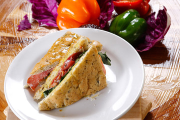 Traditional bread sandwich with serrano ham, cheese and spinach leaves.