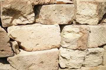 Fototapeta premium Stone wall. Brutal old cobblestone fencing. Texture of beige stones. Large light stone bricks, background.