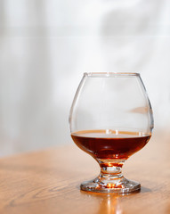 One glass of brandy on antique wooden counter top