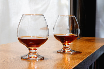 Two goblets of brandy on wooden old counter top