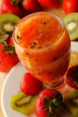 Strawberry juice with lemon served in glass and decorated with a paper umbrella.