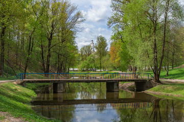 City park landscape with a bridge over a stream and with a church