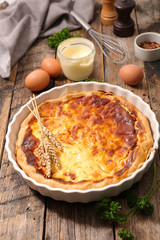 homemade quiche and ingredient on wood background