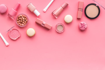 Fototapeta na wymiar Decorative cosmetics for make-up with macaroon cookies on pink tabletop background mockup