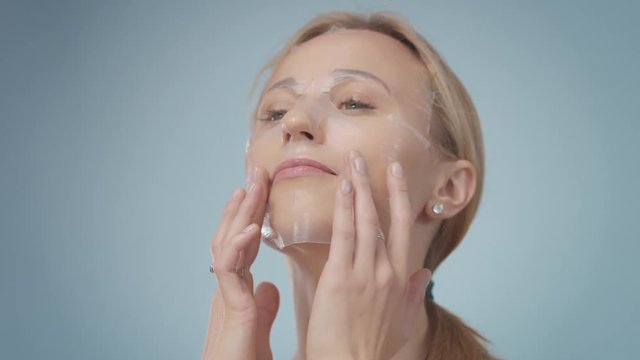 young model wear a korean facial sheet mask. Transparent sheetmask. Making a massage