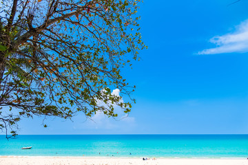 Summer seascape on tropical Phuket island in Thailand. Landscape taken on main long sunrise beach with blue sky and white sand.