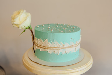 Homemade wedding cake with naturel rose on rustic wooden board.