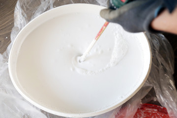 Man preparing white paint for interior walls