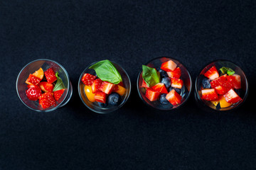 Berry frame with copy space. Four cups with sliced strawberries and blueberries.