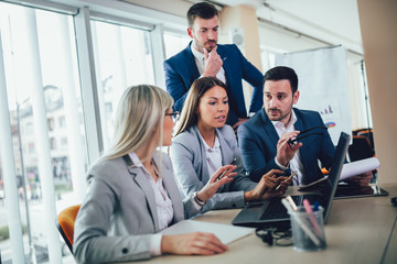 Creative business people working on business project in office using laptop.
