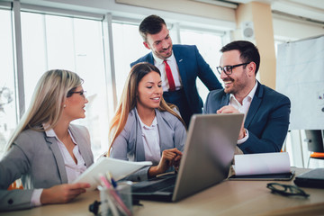 Creative business people working on business project in office using laptop.