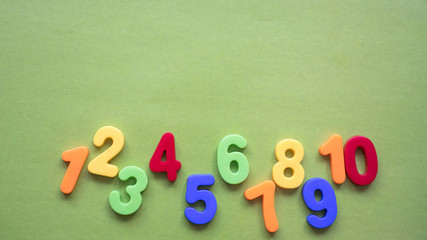 children's multi-colored numbers on a green background, copy space