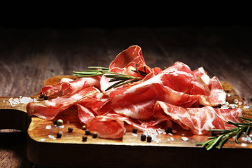 Italian sliced cured coppa with spices. Raw ham. Crudo or jamon with rosemary