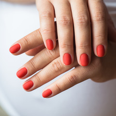 Closeup photo of a beautiful female hands with red nails