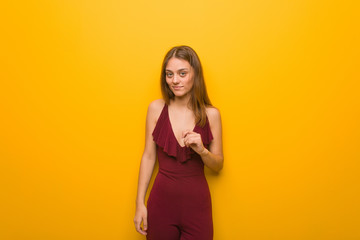 Young natural woman wearing a red dress against an orange wall