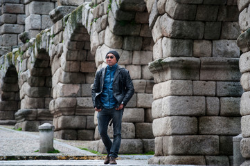 Tourist walking to Roman aqueduct in Segovia the historic city Romanesque architecture locate at northwest of Madrid, Spain.