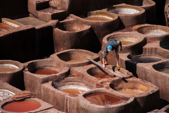 Tanneries of Fes, old big tanks of the Fez's tanneries with workers who working in a tannery on traditional craft leather dying. Morocco, Africa