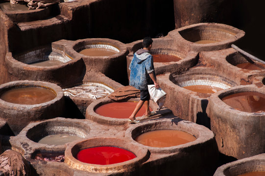 Blurred image of factory Tanneries of Fes, old big tanks of the Fez's tanneries with workers who working in a tannery on traditional craft leather dying. Morocco, Africa