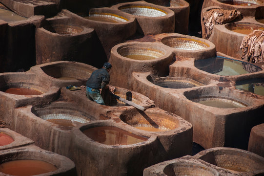 Tanneries of Fes, old big tanks of the Fez's tanneries with workers who working in a tannery on traditional craft leather dying. Morocco, Africa