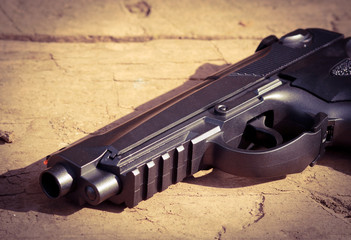 Black air gun on the wooden background.