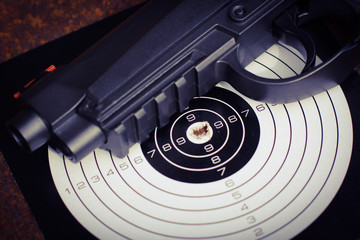 Black air gun with target on the metal grunge background.