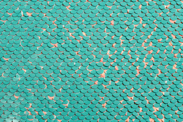 Sequin fabric background. Close-up shot of glittery blue or aquamarine colored sequins texture with...