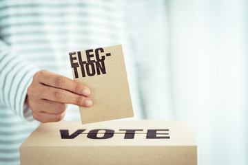 brown paper insert in vote box, bright future of democracy concept