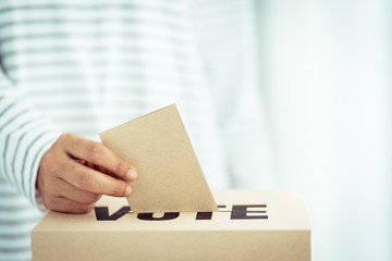 brown paper insert in vote box, bright future of democracy concept