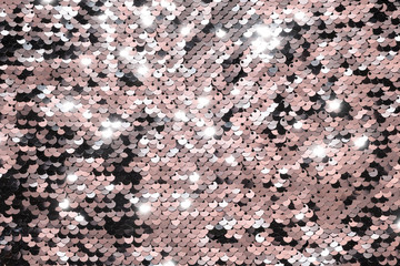 Sequin fabric background. Close-up shot of glittery black sequins texture reflecting red light