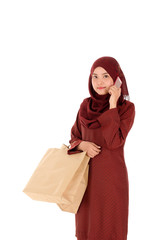 Happy young muslim woman with shopping bag isolated over white background