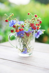 Bouquet from wild strawberry and flowers. Healthy natural food. Ecological clean products