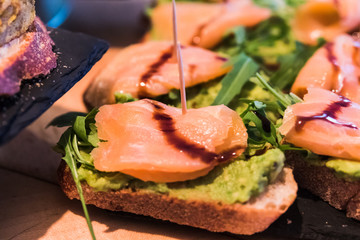 Avocado pintxos with salmon and arugula. Spanish tapas called pintxos of the Basque country