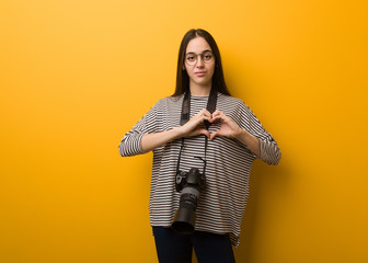 Young photographer woman doing a heart shape with hands
