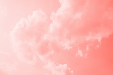 Pink coral color sky background with white clouds. Coral gradient background