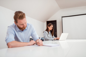 Obraz premium Two colleagues working at bright coworking office.