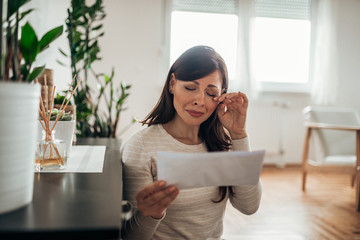 Woman reading a letter and crying.