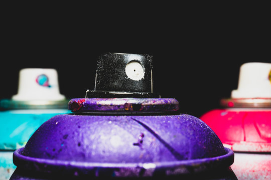 Paint spray for street art raw material for artistic work with black background. Macro and detailed image of used dirty paint material in the foreground