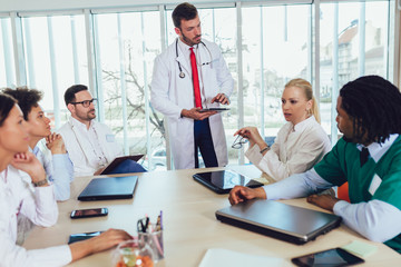 Medical team sitting and discussing at the table in the office.
