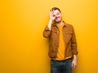 Young redhead man confident doing ok gesture on eye