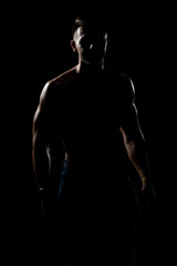 Fototapeta na wymiar Siluet Muscular Bodybuilder In Jeans Flexing Muscles