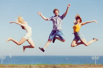 Fototapeta na wymiar Group of friends boy two girls jumping outdoor