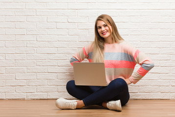 Young russian student woman sitting with hands on hips