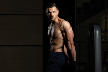 Fototapeta na wymiar Muscular Man Flexing Muscles Side Triceps Pose