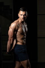 Fototapeta na wymiar Handsome Bodybuilder Making Side Triceps Pose