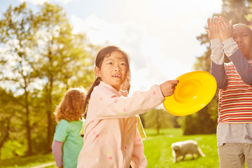 Kinder spielen Frisbee zusammen im Park