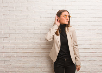 Young pretty business entrepreneur woman try to listening a gossip