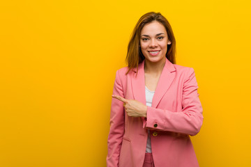 Young fashion business woman smiling and pointing aside, showing something at blank space.