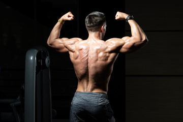 Fototapeta na wymiar Muscular Man Flexing Muscles Rear Double Biceps Pose