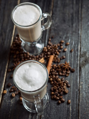 Coffee with milk in a glass on dark wooden background