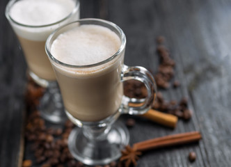 Coffee with milk in a glass on dark wooden background